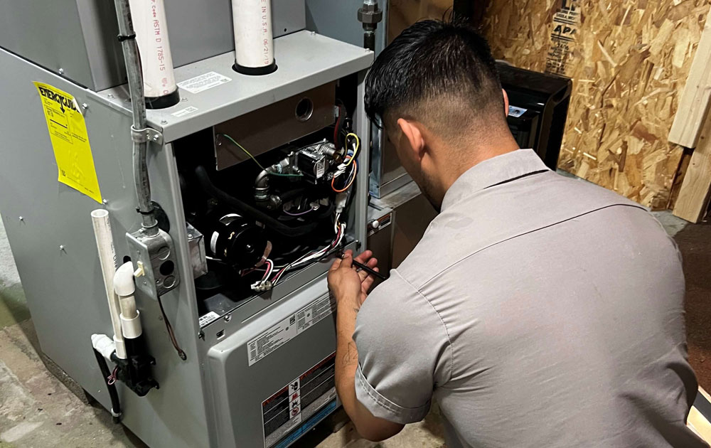 Over the Moon HVAC Technician Servicing a Furnace