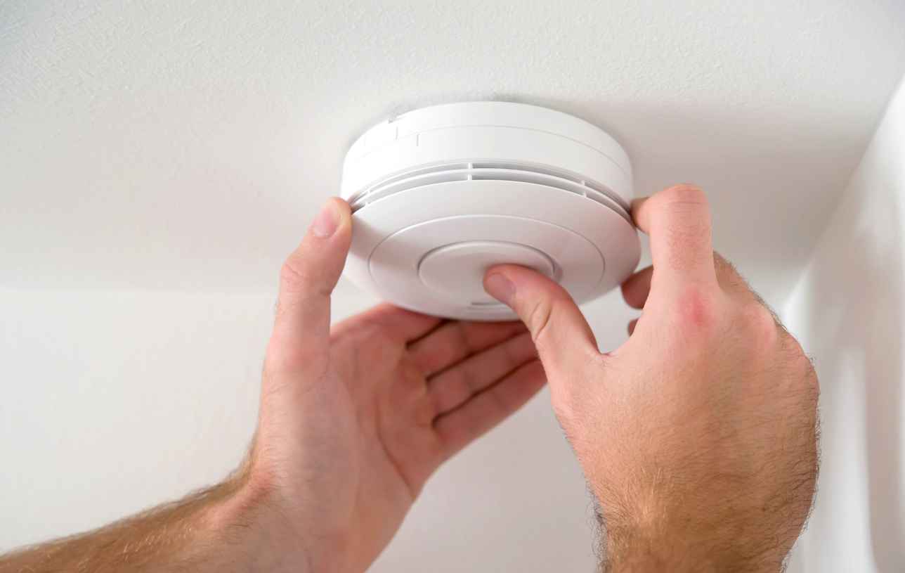 Man installing smoke or carbon monoxide detector