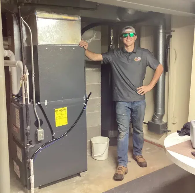 Technician smiling in front of furnace in Brookfield